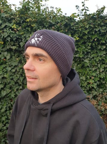 Photo of man wearing a dark grey beanie with The Cally Collection logo in white on the front.   The man is also wearing a black hoodie from The Cally Collection.