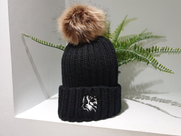 Black chunky beanie from The Cally Collection with removable brown faux fur bobble.    The Cally Collection logo is in white in the centre of the front fold.