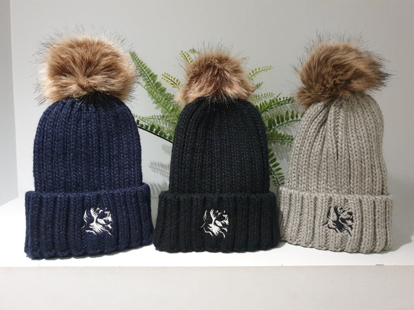 The Cally Collection chunky beanies, all with removable bobbles in brown faux fur. Available in navy blue, black and light grey, all with The Cally Collection logo in the centre of the front fold.