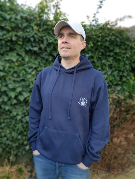 Photo of man wearing a navy hoody with The Cally Collection logo in white in the top left corner.   The man is also wearing a light grey air mesh cap with The Cally Collection logo in white on the front panel.