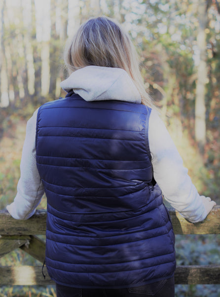 Photo of back of lady wearing a light grey hoody from The Cally Collection, with a navy gilet also from The Cally Collection.