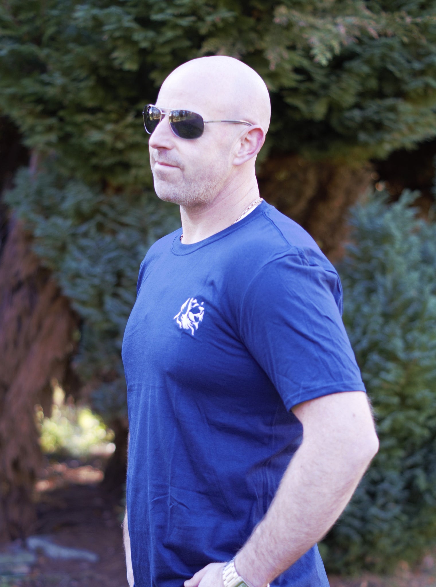 Photo of man wearing navy t-shirt with The Cally Collection logo in white in the top left corner.