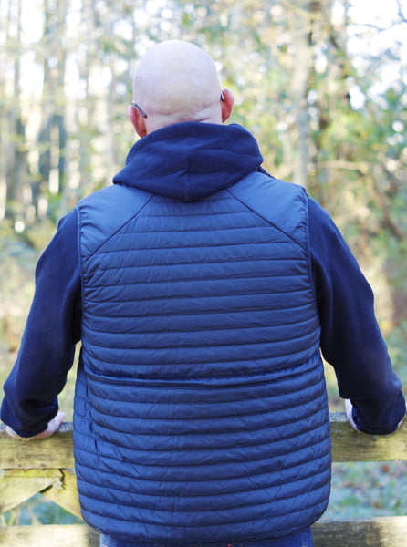 Photo of back of man wearing a navy hoody from The Cally Collection, with a navy gilet with lime trim from The Cally Collection.