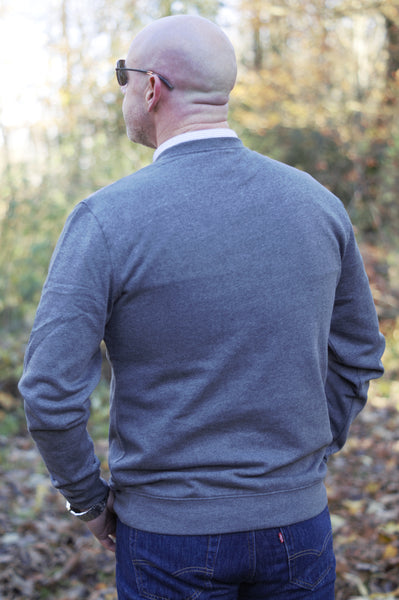 Photo of back of man wearing a dark grey sweatshirt from The Cally Collection.