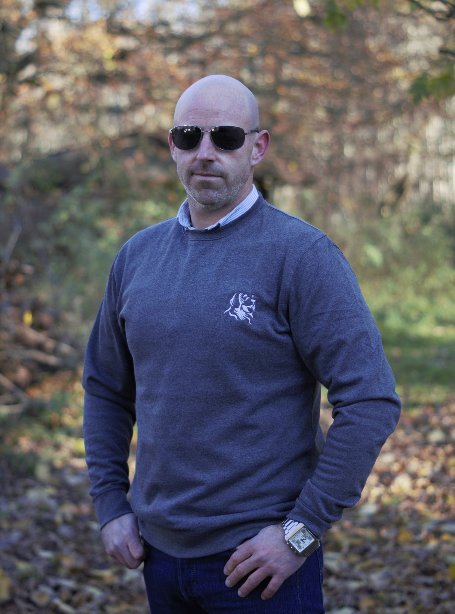 Photo of man wearing a dark grey sweatshirt with The Cally Collection logo in white in the top left corner.