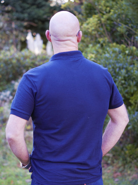 Photo of back of man wearing navy polo shirt from The Cally Collection.