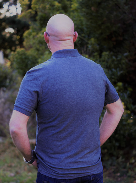 Photo of back of man wearing dark grey polo shirt from The Cally Collection.