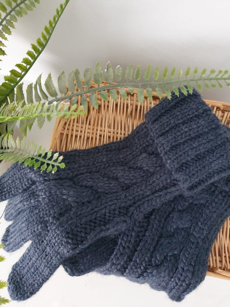 Photo of a pair of cable knit gloves in navy.